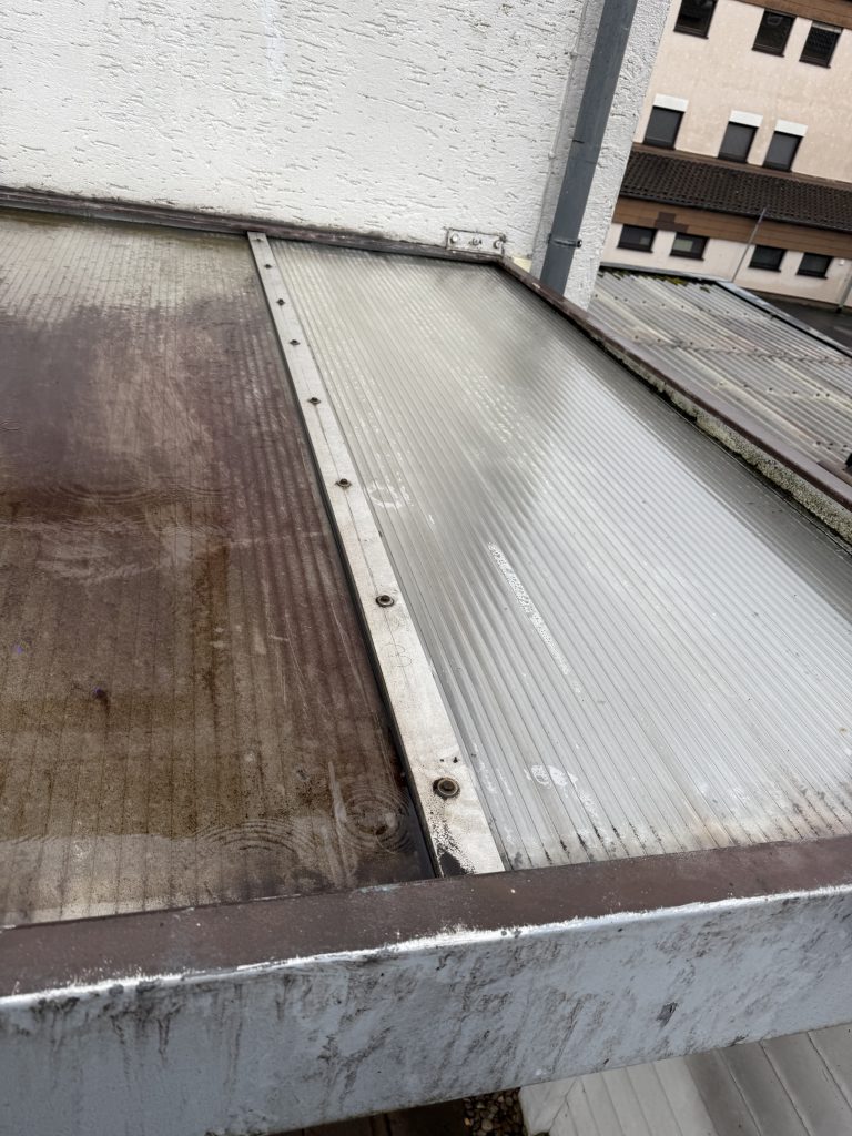 Teilweise gereinigte Überdachung – links schmutzig, rechts sauber und lichtdurchlässig