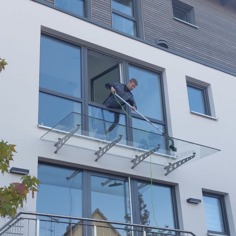 Reinigung eines Daches über dem Eingang